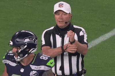 A Referee Wearing A Nfl Hat Talks To A Football Player GIF