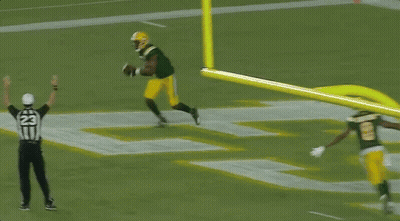 A Referee With The Number 22 On His Hat Watches A Football Player GIF