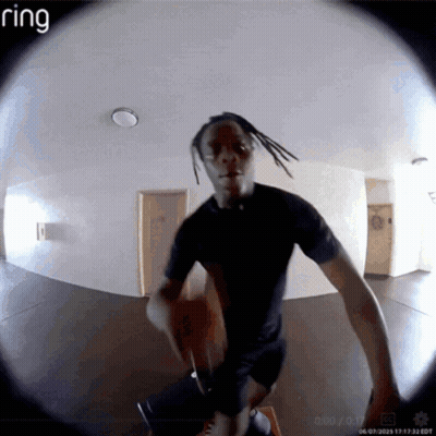 A Ring Camera Shows A Man In A Black Shirt Standing In A Hallway GIF