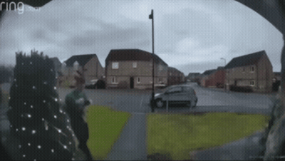 A Ring Doorbell Shows A Man Walking Down A Residential Street GIF