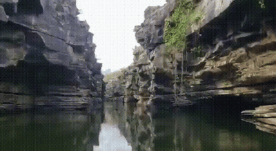 A River Runs Through A Narrow Canyon Surrounded By Cliffs GIF