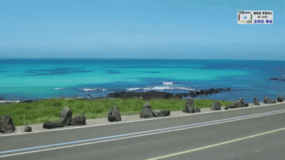 A Road Going Towards The Ocean With A Sign That Says 4K Uhd On It GIF