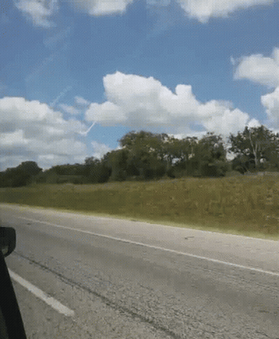 A Road With Trees On The Side Of It And A Blue Sky GIF