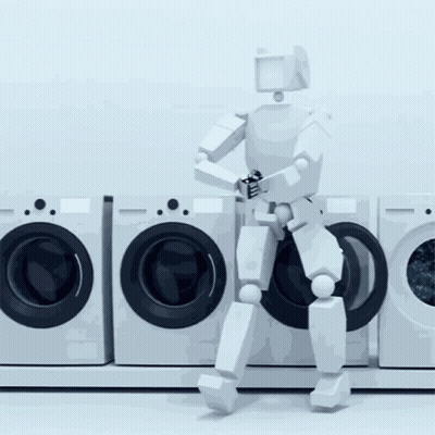 A Robot Is Standing In Front Of A Row Of Washers GIF