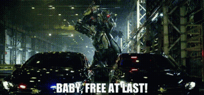 A Robot Is Standing Next To A Car With The Words Baby Free At Last Written On It GIF