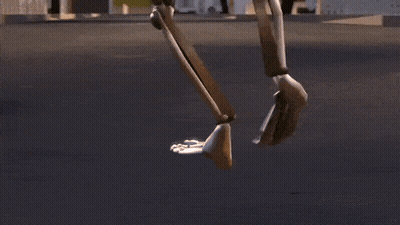 A Robot Is Walking Down A Street In A Video Game GIF