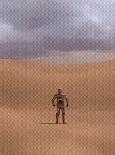 A Robot Stands In The Middle Of A Desert With His Hands On His Hips GIF