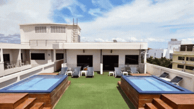 A Rooftop With A Swimming Pool And Chairs GIF