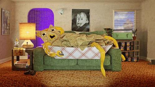 A Room With A Green Couch And A Box Of Potato Chips On The Floor GIF