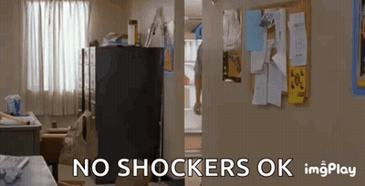 A Room With A Refrigerator And A Bulletin Board With The Words `` No Shockers Ok '' Written On It . GIF