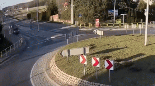 A Roundabout With A Few Signs And A Sign That Says Hilfe Gorsey Katz GIF