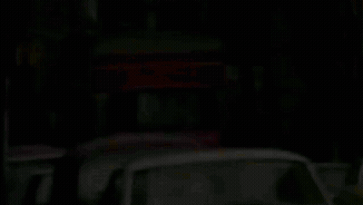 A Row Of Cars Are Parked On The Side Of The Road GIF