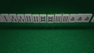 A Row Of Chinese Mahjong Tiles On A Green Mat GIF