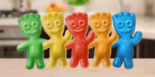 A Row Of Colorful Gummy Bears Are Sitting On A Counter GIF