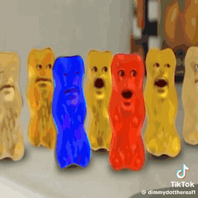 A Row Of Gummy Bears With Faces Are Lined Up In A Row GIF