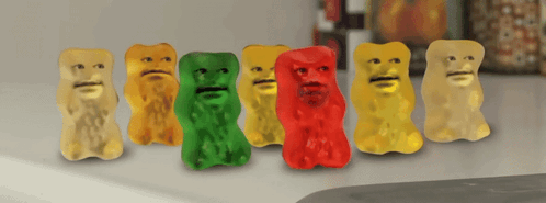A Row Of Gummy Bears With Faces Are Lined Up On A Counter GIF