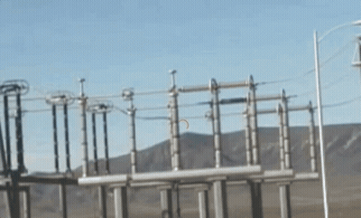 A Row Of Power Lines With Mountains In The Background GIF