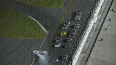 A Row Of Race Cars Are Lined Up On A Race Track And One Of Them Has The Word Ford On The Side GIF