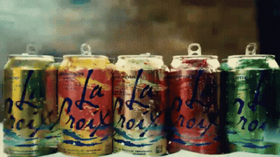 A Row Of Soda Cans With One That Says ' La ' On It GIF