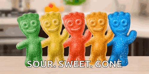 A Row Of Sour Sweet Gone Gummy Bears Are Lined Up On A Table GIF
