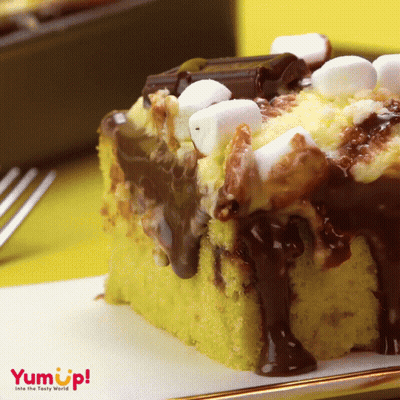 A S'mores Cake With Chocolate Sauce And Marshmallows On Top Of It GIF