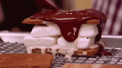 A S'mores Sandwich With Marshmallows And Chocolate Sauce Being Poured Over It . GIF