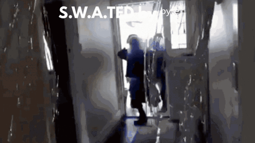 A S.w.a.t.f.i. Officer Stands In A Hallway GIF