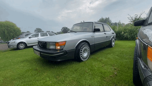 A Saab Car Is Parked In A Grassy Area GIF