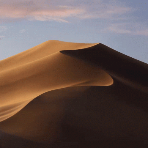 A Sand Dune In The Desert With A Blue Sky Behind It GIF