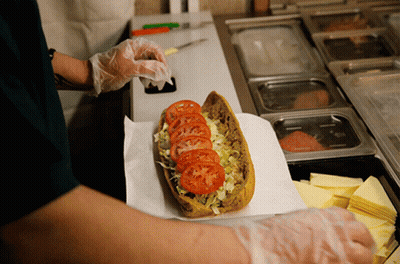 A Sandwich With Tomatoes Lettuce And Cheese Is Being Prepared GIF