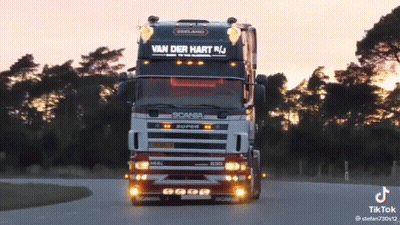 A Scania Truck Is Driving Down The Road GIF