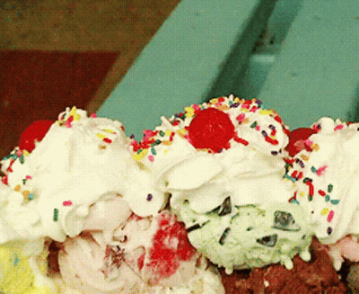 A Scoop Of Ice Cream With Whipped Cream And Sprinkles And A Cherry On Top GIF