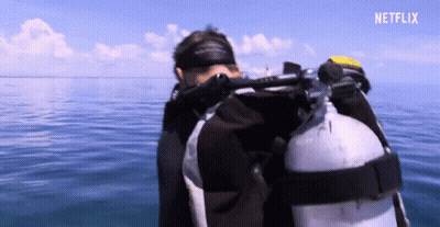 A Scuba Diver In The Ocean With A Netflix Logo In The Upper Right Corner GIF