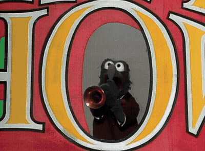 A Sesame Street Character Is Playing A Trumpet In Front Of A Sign That Says Hot GIF