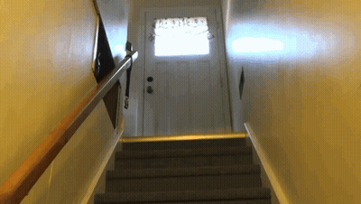 A Set Of Stairs Leading Up To A Door With A Curtains On It GIF