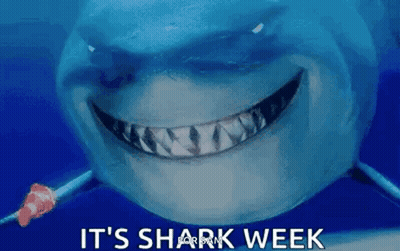 A Shark Is Smiling With The Words `` It 'S Shark Week '' Above It . GIF