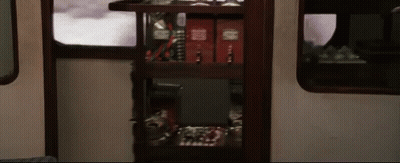 A Shelf In A Train Car Has A Few Books On It Including One That Says ' Harry Potter ' On It GIF