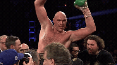 A Shirtless Boxer Is Being Congratulated By A Group Of People GIF