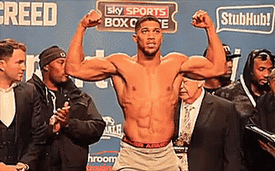A Shirtless Boxer Is Flexing His Muscles In Front Of A Sign That Says Sky Sports Box Office GIF
