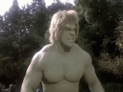 A Shirtless Hulk With Blonde Hair Is Standing In Front Of A Forest . GIF