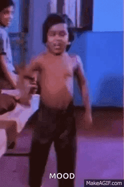 A Shirtless Little Boy Is Dancing In A Room With A Man Sitting In The Background . GIF