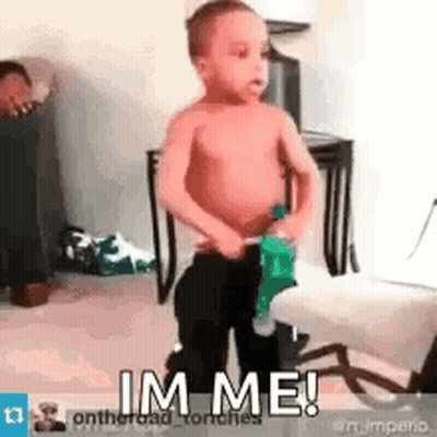 A Shirtless Little Boy Is Standing In A Room Holding A Bottle Of Soda And Says `` Im Me '' . GIF
