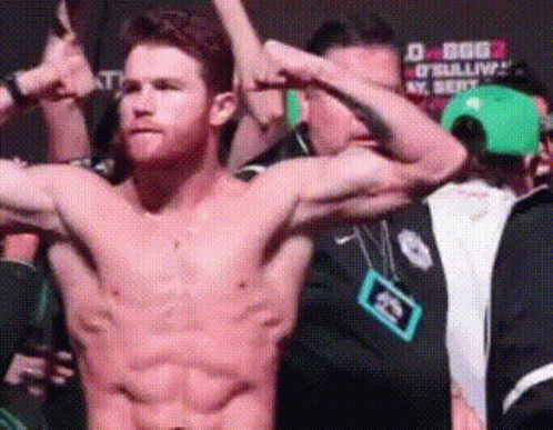 A Shirtless Man Flexes His Muscles In Front Of A Crowd GIF
