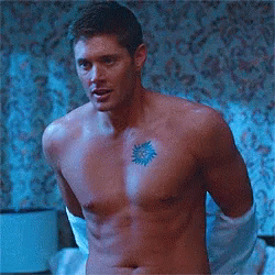 A Shirtless Man Has A Tattoo Of A Sun On His Chest . GIF