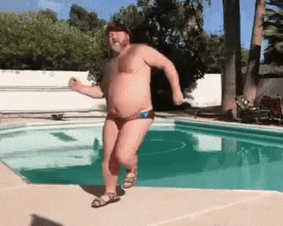 A Shirtless Man In A Bathing Suit Is Dancing In A Pool . GIF