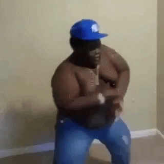 A Shirtless Man In A Blue Hat Is Standing In A Room . GIF