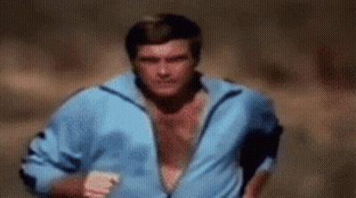 A Shirtless Man In A Blue Jacket Is Running . GIF