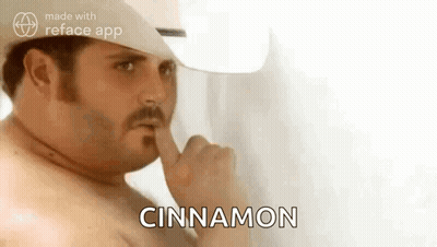 A Shirtless Man In A Cowboy Hat Is Holding His Finger To His Mouth And Saying `` Cinnamon '' . GIF