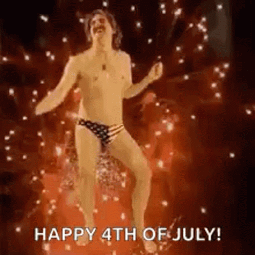 A Shirtless Man In A Polka Dot Swim Trunks Is Dancing In Front Of A Fireworks Display . GIF