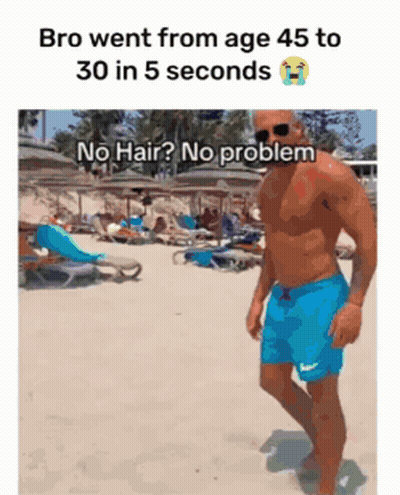 A Shirtless Man In Blue Shorts Is Walking On The Beach GIF